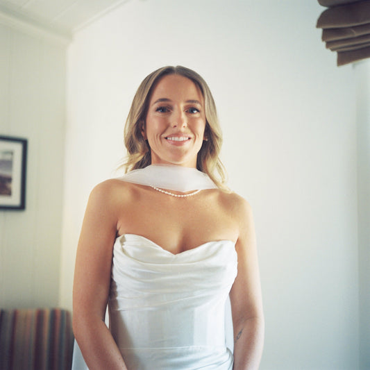 strapless corset dress with pearl necklace and bridal scarf