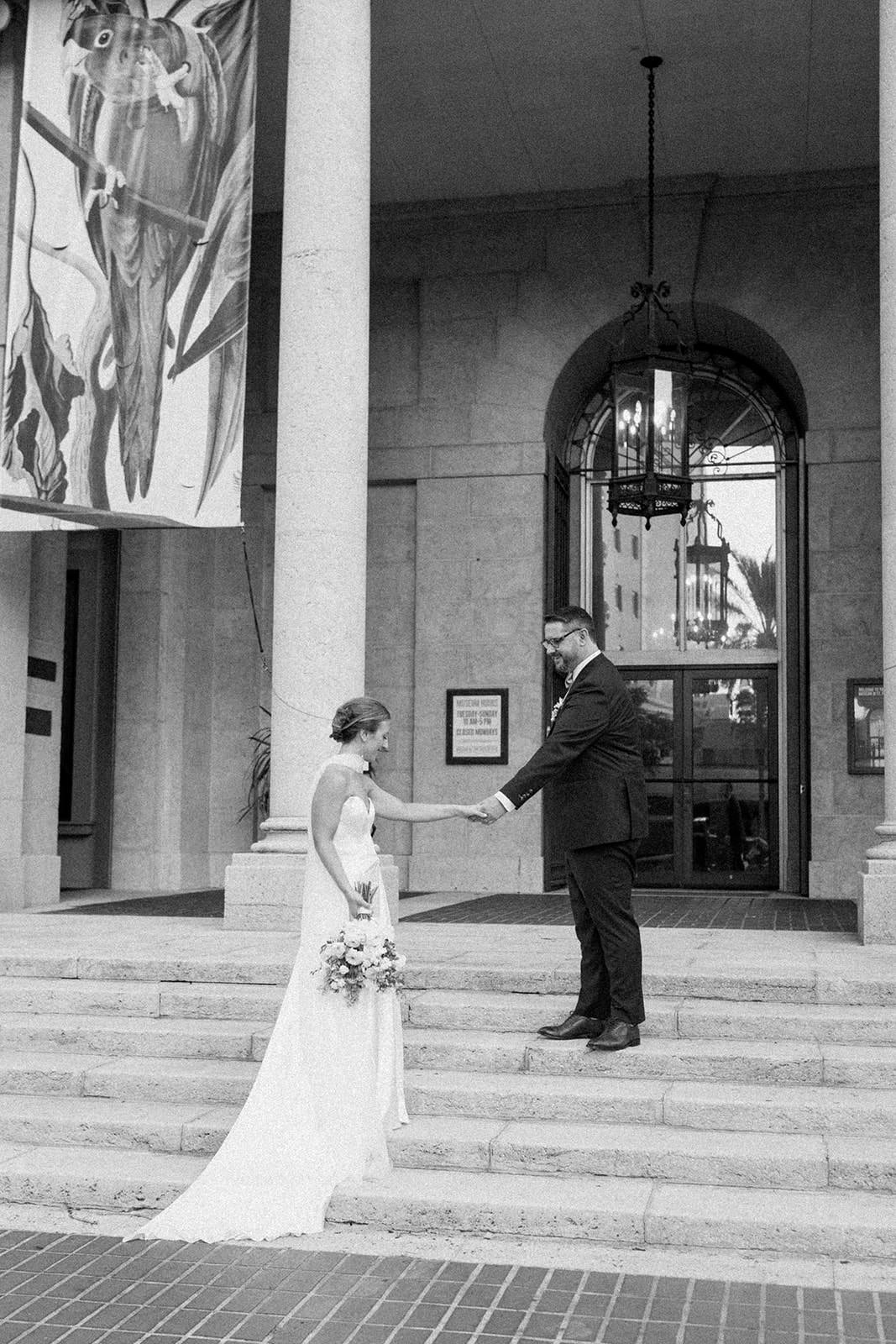 fine art museum wedding with bride going up steps wearing long silk satin neck scarf